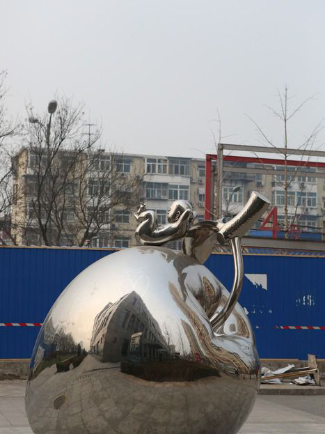 城市不锈钢躺在苹果上的小孩雕塑图片